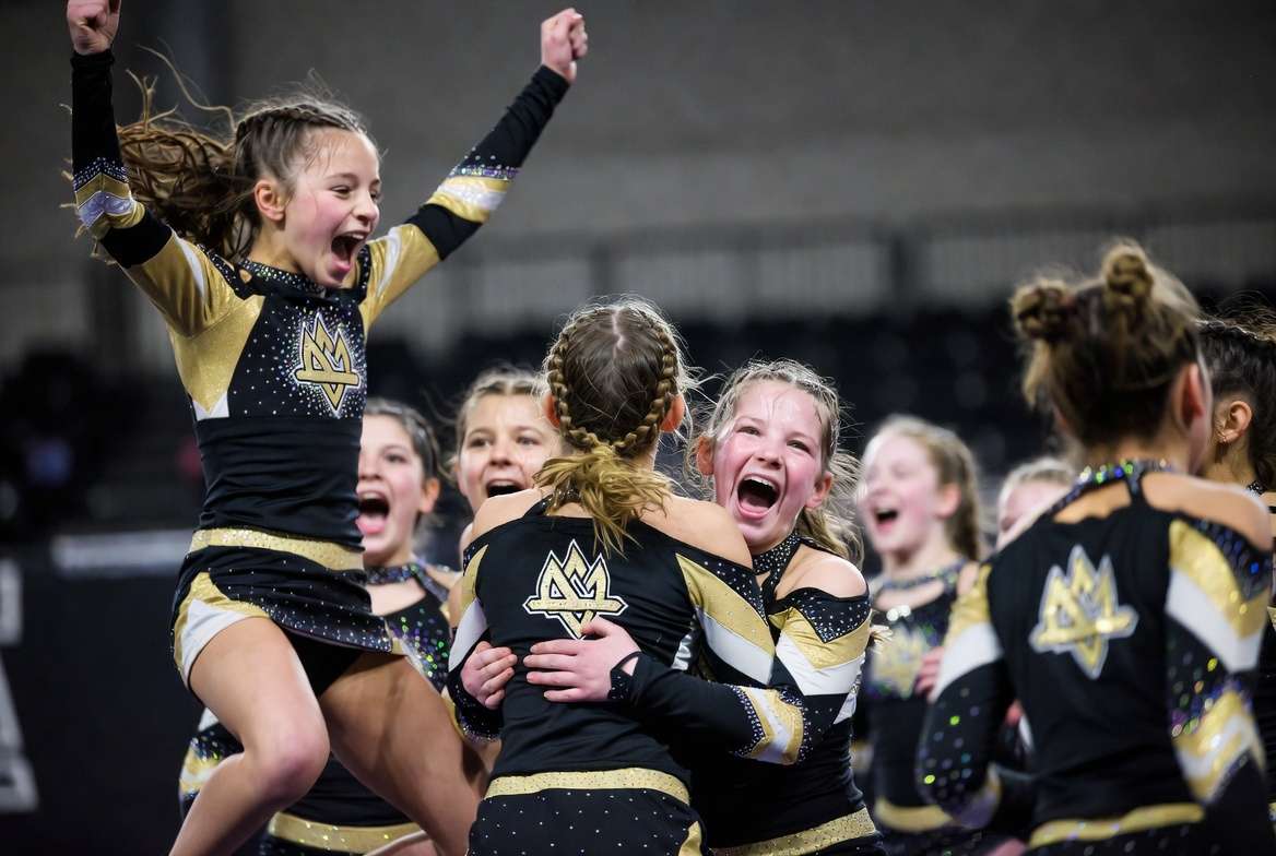 Youth cheer team celebrating after hitting zero at a competition, the moment a season of work pays off